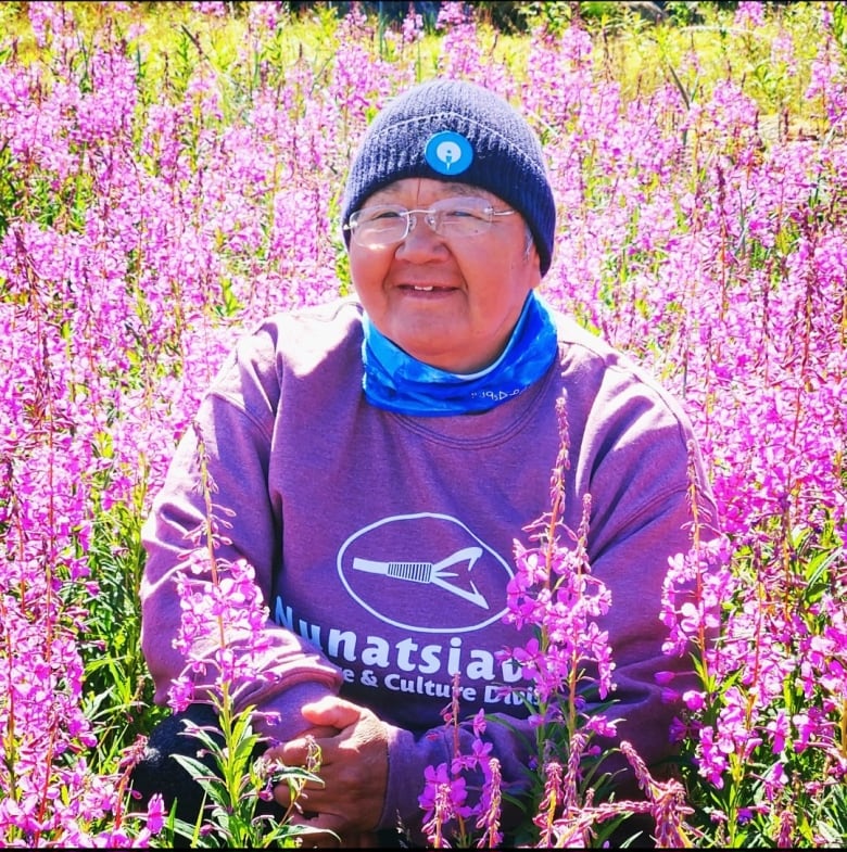 A woman wearing a purple shirt that says 