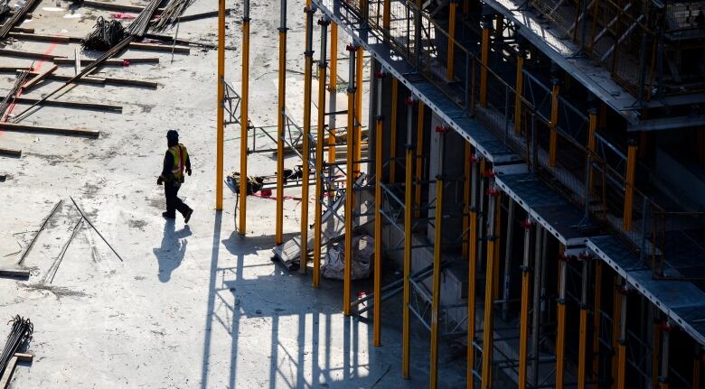 A construction worker walks through a building site.