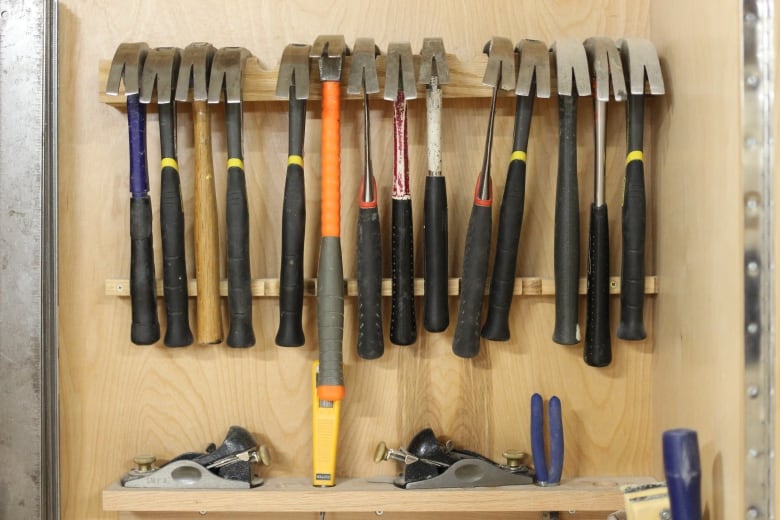 A display of hammers inside a wood shed.