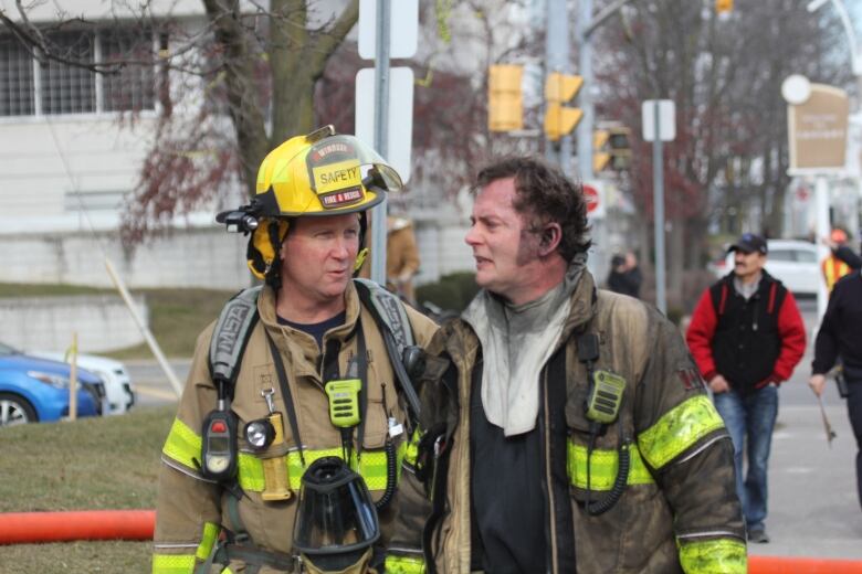 Two Windsor firefighters near the scene of a Feb. 8, 2024 highrise fire in the city.