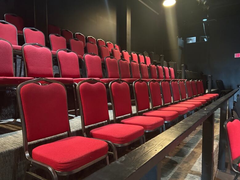 a row of red chairs in the theater at the Guild. 