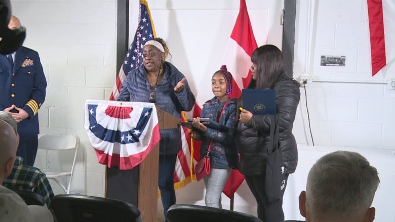 Three people stand at a podium