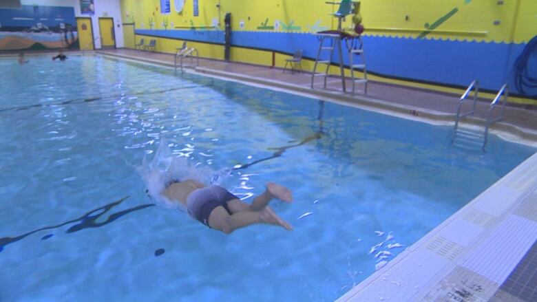 A man is diving into a swimming pool.