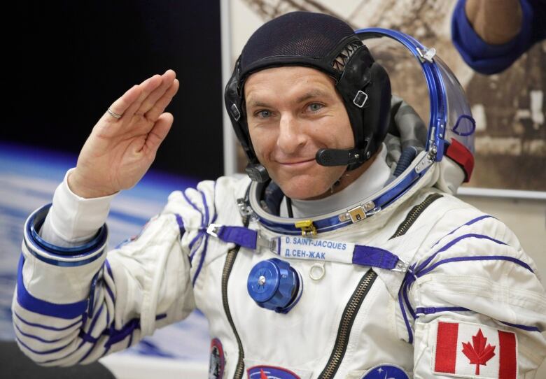 A Canadian astronaut in full uniform gestures prior to departing to the International Space Station in late 2018.