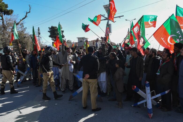 Police guard the office of a returning officer as supporters of Pakistan Tehreek-e-Insaf (PTI) and other parties protest against alleged vote-rigging in Pakistan's national election.