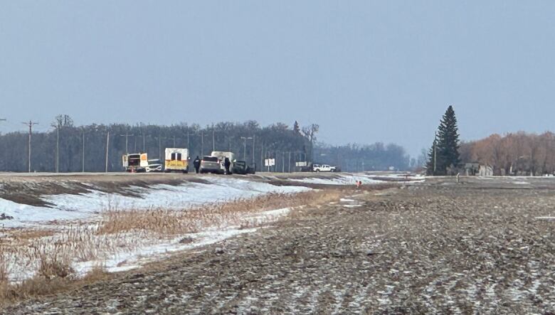 Vehicles on a road that is blocked off.