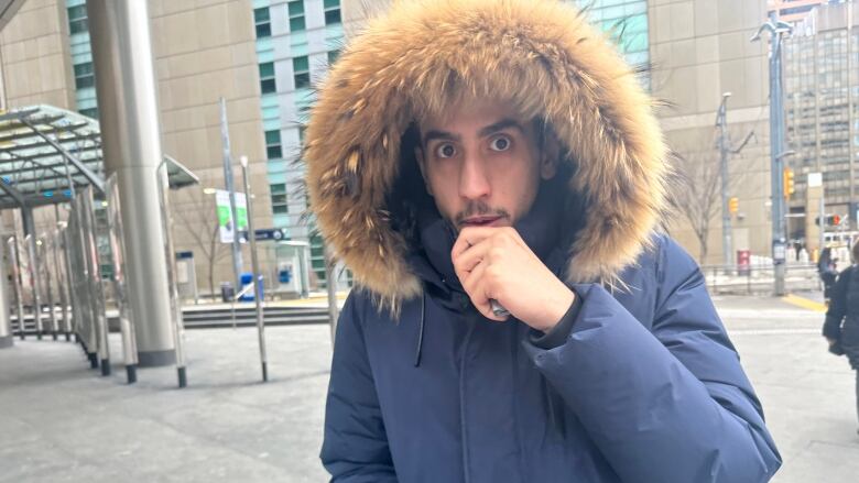 A man in a parka vapes while leaving the courthouse. 