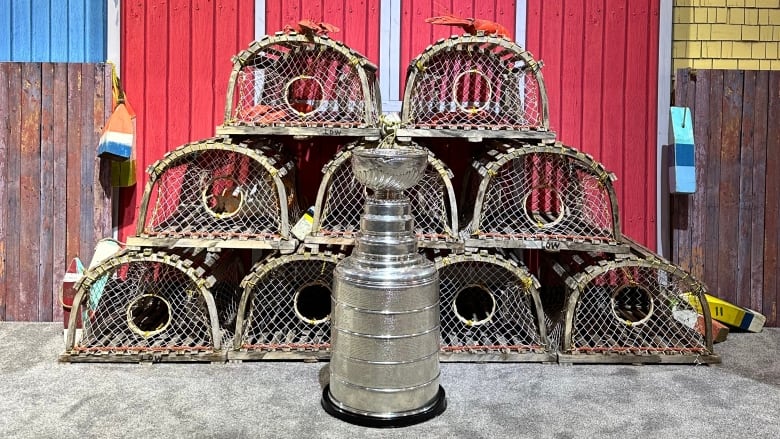 A P.E.I. tourism booth depicting a red barn with lobster traps in front and the Stanley Cup in the foreground.