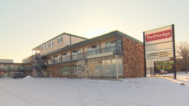 A brick motel building with a sign next to it that reads 