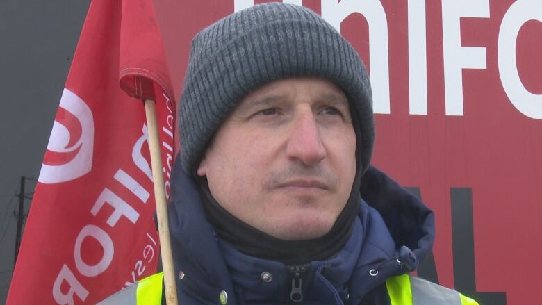 A striking worker on a picket line during winter.