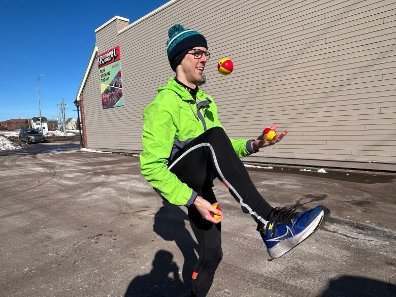 A white man doing a juggling trick with three balls.