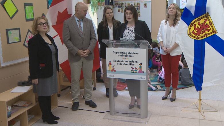 A group of people stand around a podium.