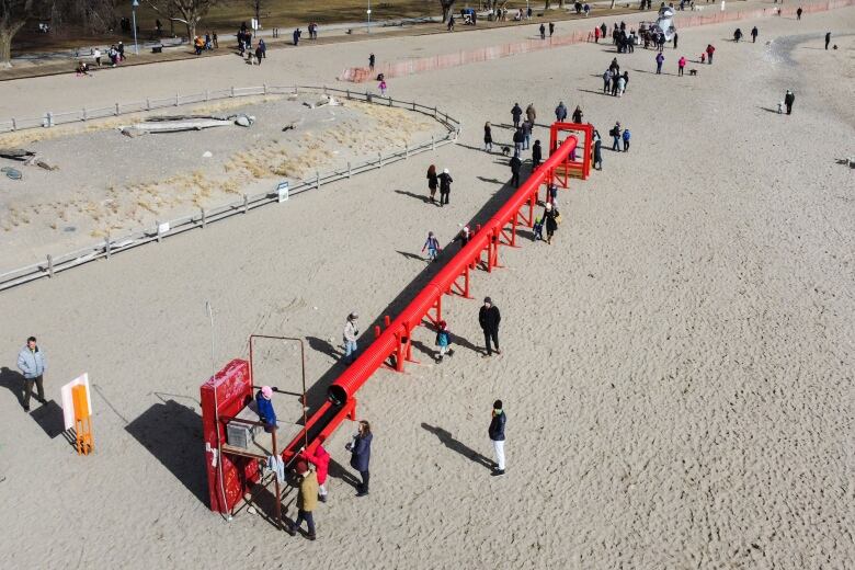 An art exhibit on a beach, with people milling about.