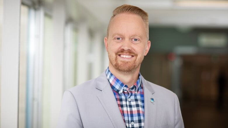 A man in a suit smiling at the camera.