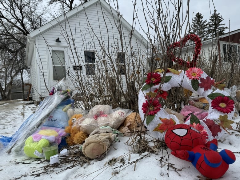 Toys, flowers and a wreath lying around a house.