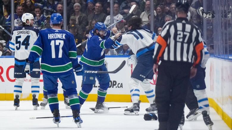 Two hockey players fight.