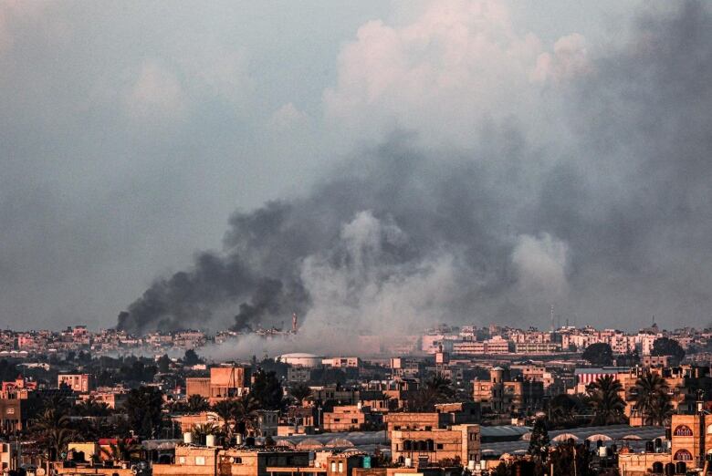 Smoke billows over a city.