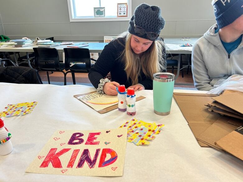 A woman draws a sign