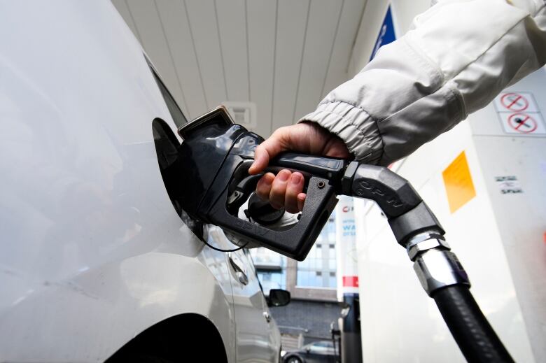 A person places a gas pump in their car.