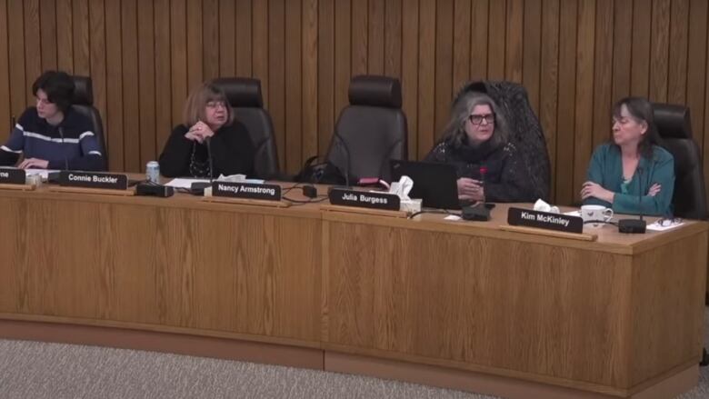 Four trustees sitting at a desk