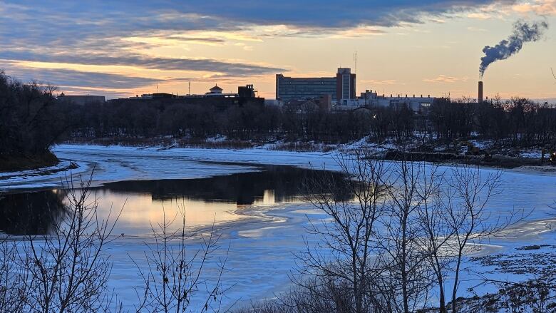 Open water is seen on the Red River, surrounded by ice and snow. 