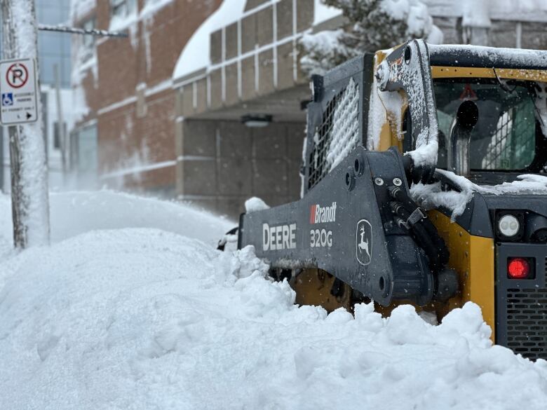 A tractor clears snow in downtown Sydney during the 2024 record snowfall.