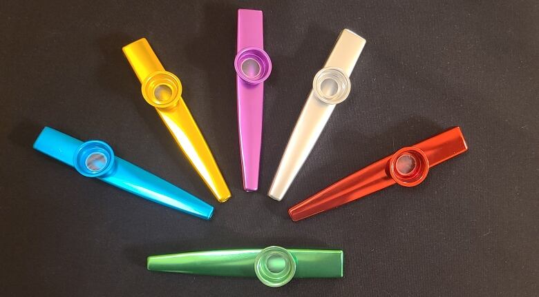 Six kazoos are placed on a tabel