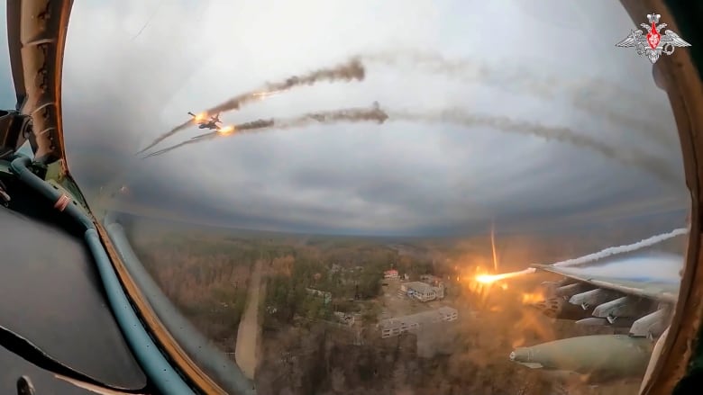 A warplane in flight fires rockets.