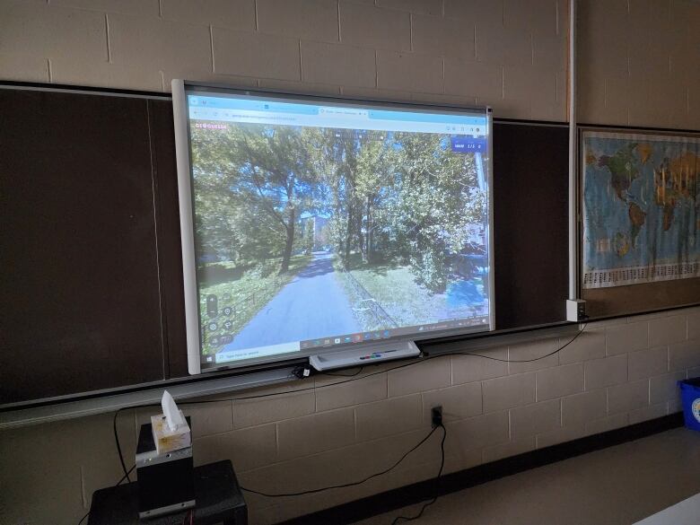 A smart board at the front of a classroom with Google Streetview on it.