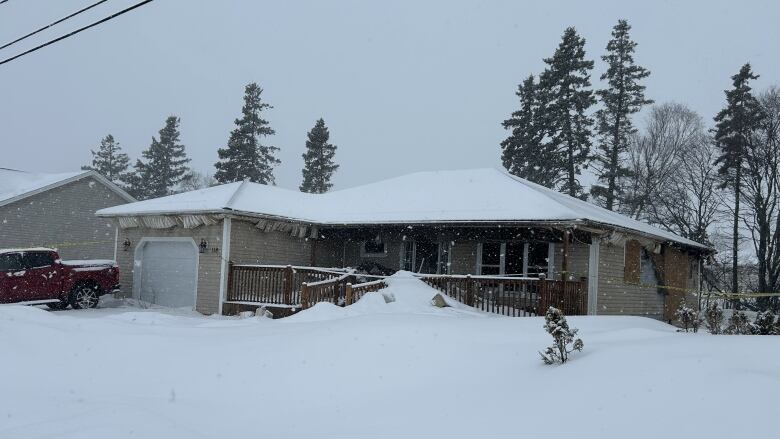 House with yellow police tape surrounding it.