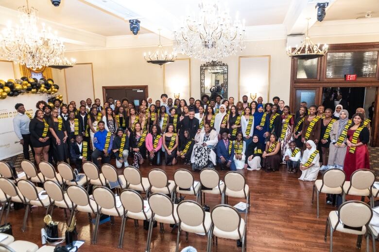 People standing wearing sashes.