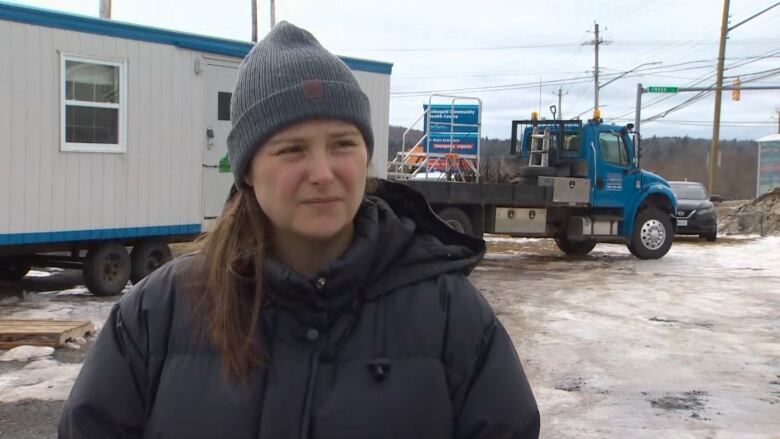 A woman stands at a construction site.