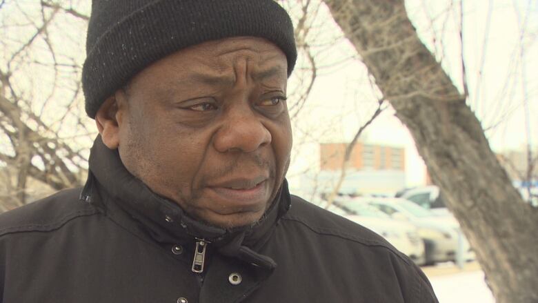 A man wearing a toque is interviewed by a reporter (not pictured)