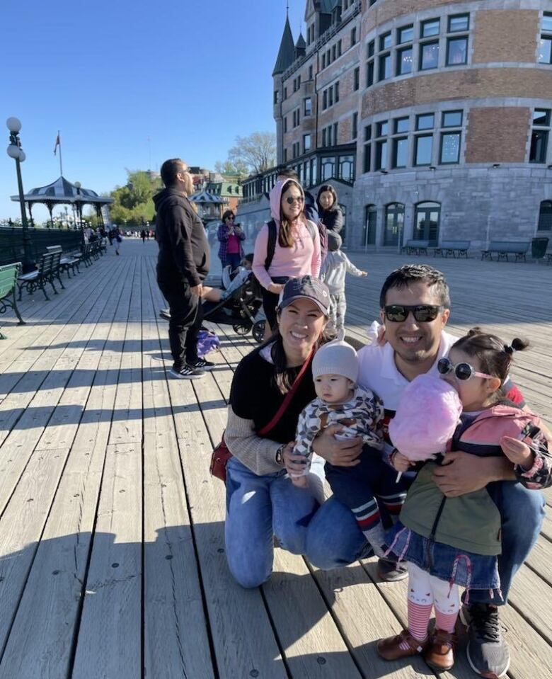 Mom, dad and two little kids pose on the Quebec City boardwalk near the Chteau Frontenac.