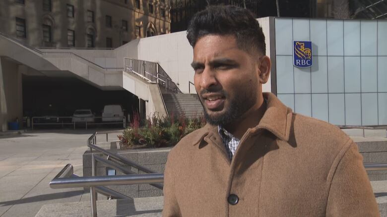 A man is shown outside in front of an office building.