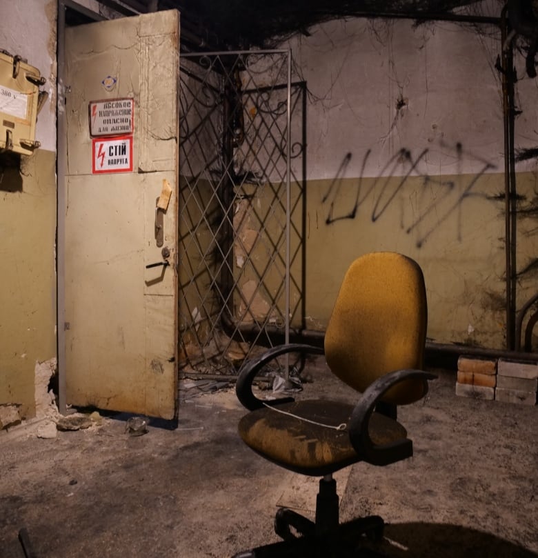 A brown chair sits in the middle of a purported torture facility. The door has been propped open.