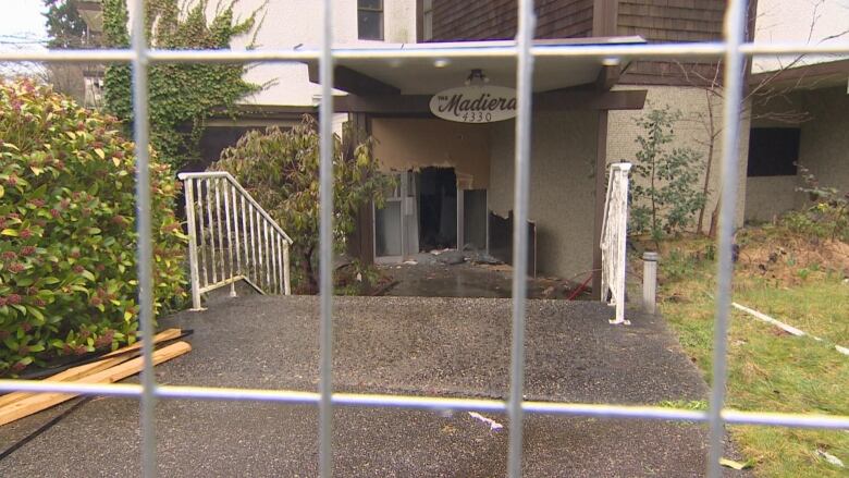 A smashed door is shown in a building with a sign saying 