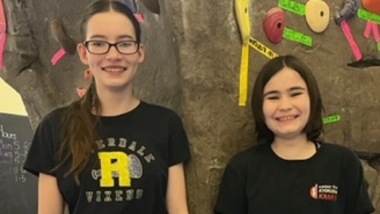 Two girls at a climbing gym.