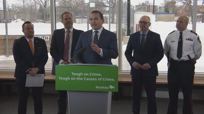 Five men, including politicians and police representatives, stand next to each other at an announcement.