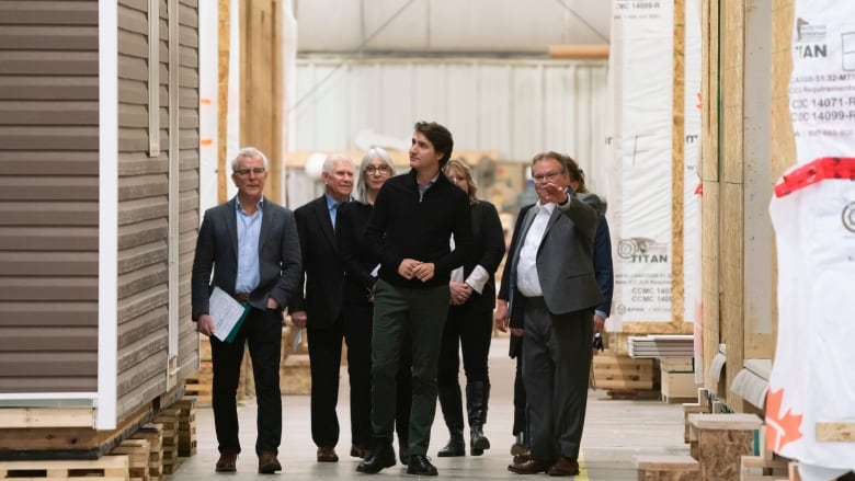 A group of people walk in a warehouse building