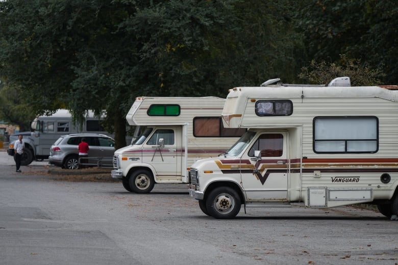 Two RVs sit on concrete. They are older model Vanguards.