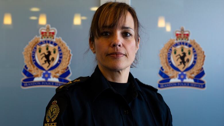 A police officer stands in front of a door.