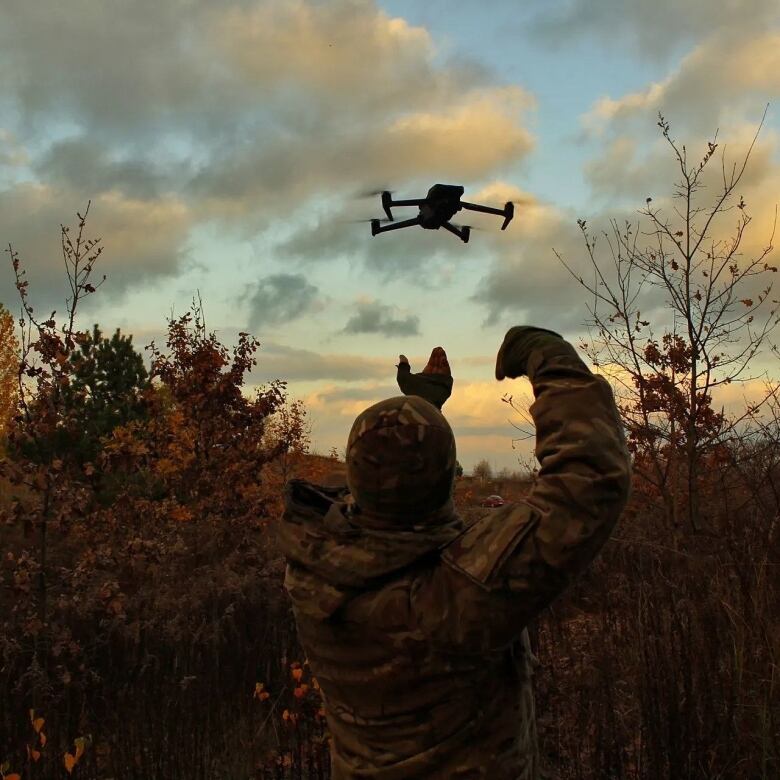 This photo, submitted to CBC News by Ukraine's Dronarium Academy, shows a drone in flight, with a person in the foreground.