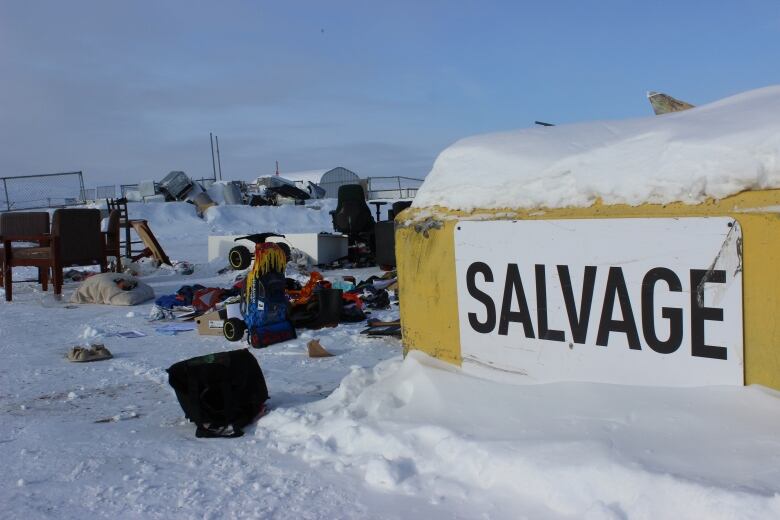 A concrete-looking block, painted yellow, with a white sign that says 