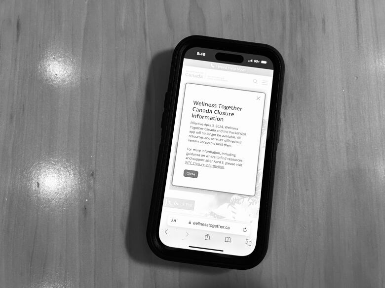 Black and white photo of phone showing an alert saying 