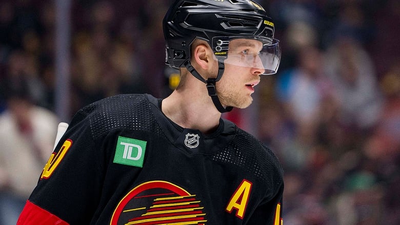 A Vancouver Canucks forward stands on the ice during a stop in play against the Los Angeles Kings during a Feb. 29, 2024 game.