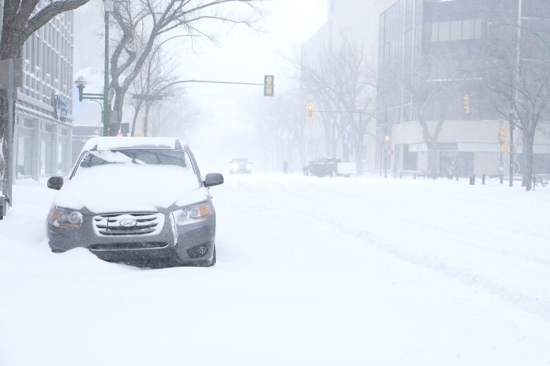 A car is sitting in a snow bank in downtown saskatoon