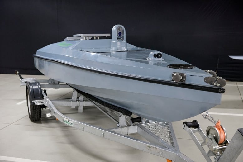 A sleek boat is shown inside a building resting on a trailer.