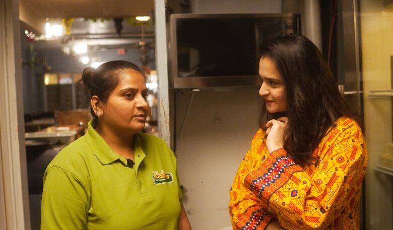 Filmmaker Ayesha Mohsin chats with cook Sonal Patel in the kitchen of Shree Akshar Restaurant in Regina.