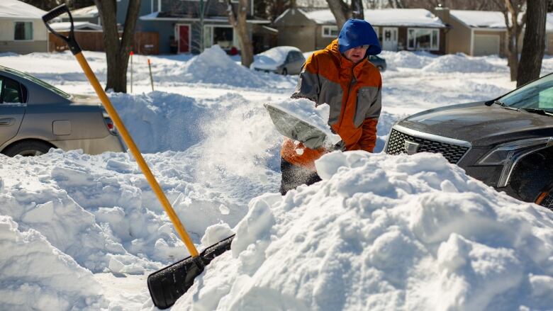 A man shovels snow.